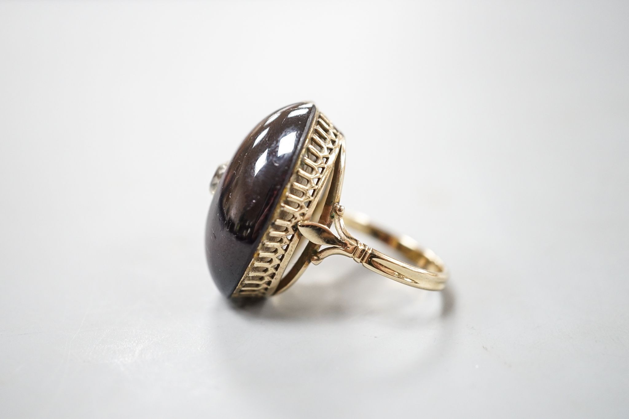 A yellow metal, foil backed cabochon garnet and diamond set oval dress ring, size P/Q, gross 11.1 grams, (a.f.).